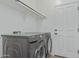 Modern laundry room featuring a gray front-load washer and dryer set with built-in shelving at 4273 S Red Rock St, Gilbert, AZ 85297