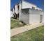 Angle view of the townhome's stucco siding and cozy, fenced-in front patio, surrounded by a green lawn at 5212 N 42Nd Ln, Phoenix, AZ 85019