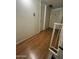 Bright hallway with laminate wood flooring leads to a white door, offering a simple, clean aesthetic at 5212 N 42Nd Ln, Phoenix, AZ 85019