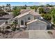 Two-story home showcasing a three-car garage and a well-maintained desert-style front yard with decorative rock landscaping at 5402 E Helena Dr, Scottsdale, AZ 85254