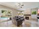Cozy living room with a stone fireplace, neutral tones, and seamless access to the backyard pool area through sliding glass doors at 5402 E Helena Dr, Scottsdale, AZ 85254