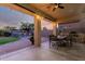 Covered patio with outdoor seating, a built-in grill, a lush lawn and a cozy fireplace in the background at 5424 N 186Th Dr, Litchfield Park, AZ 85340