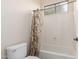 Bright bathroom featuring a tub with shower and toilet underneath a window, and neutral decor at 5424 N 186Th Dr, Litchfield Park, AZ 85340