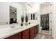 Bathroom featuring double sinks, large mirror, and neutral tile at 5424 N 186Th Dr, Litchfield Park, AZ 85340