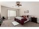 Inviting bedroom with plush carpeting, a ceiling fan, and large windows, creating a relaxing and comfortable retreat at 5424 N 186Th Dr, Litchfield Park, AZ 85340