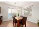 Bright dining room with large windows, stylish chandelier, and a stone table with seating for six guests at 5424 N 186Th Dr, Litchfield Park, AZ 85340