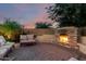 Cozy backyard stone fireplace and seating area, perfect for relaxing evenings and outdoor gatherings at 5424 N 186Th Dr, Litchfield Park, AZ 85340