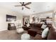 Spacious living room features a comfortable brown sectional, ceiling fan, and neutral tones at 5424 N 186Th Dr, Litchfield Park, AZ 85340