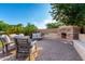 Relaxing backyard patio with comfortable seating area and a charming outdoor fireplace feature at 5424 N 186Th Dr, Litchfield Park, AZ 85340