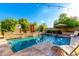 Sparkling pool with lounge chairs, lush landscaping, and a decorative water feature at 5424 N 186Th Dr, Litchfield Park, AZ 85340