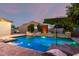 Inviting pool featuring an umbrella-covered table and water features, set against lush landscaping at 5424 N 186Th Dr, Litchfield Park, AZ 85340