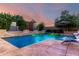 Backyard pool with lounge chairs and lush landscape with a waterfall feature at 5424 N 186Th Dr, Litchfield Park, AZ 85340