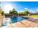 Inviting pool and spa area with lush landscaping, lounge chairs, and string lights for ambiance at 5424 N 186Th Dr, Litchfield Park, AZ 85340