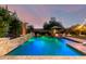 Stunning pool featuring a stone waterfall, lush landscaping, and ample space for outdoor entertaining and relaxation at 5424 N 186Th Dr, Litchfield Park, AZ 85340