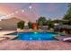 Inviting backyard pool with lush landscaping, a built-in water feature, and lounge chairs, perfect for relaxation at 5424 N 186Th Dr, Litchfield Park, AZ 85340