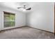 Bright bedroom featuring a ceiling fan, neutral walls, plush carpeting, and a large window at 5536 N Camelback Canyon Pl, Phoenix, AZ 85018