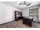 Bedroom boasts ceiling fan, neutral walls, and carpet plus built-in desk and shelving perfect for work or study at 5536 N Camelback Canyon Pl, Phoenix, AZ 85018