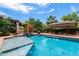 The sparkling pool is surrounded by lush landscaping, mature trees, and comfortable seating areas for outdoor fun at 5536 N Camelback Canyon Pl, Phoenix, AZ 85018