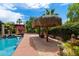 Lush backyard featuring a refreshing swimming pool and a charming tiki umbrella for relaxing in the shade at 5536 N Camelback Canyon Pl, Phoenix, AZ 85018
