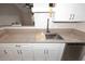 This well-lit kitchen features granite countertops, modern faucet, large stainless steel sink, and white shaker cabinets at 623 W Guadalupe Rd # 279, Mesa, AZ 85210