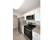 A modern kitchen offers stainless steel appliances, white cabinets, granite countertops, and wood look floors at 623 W Guadalupe Rd # 279, Mesa, AZ 85210