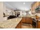An open kitchen with granite countertops, wood cabinets, and stainless steel appliances overlooks the adjacent living spaces at 641 W Mesquite Tree Ln, San Tan Valley, AZ 85143