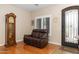 Cozy living room with hardwood floors, a decorative door, and a grandfather clock at 641 W Mesquite Tree Ln, San Tan Valley, AZ 85143