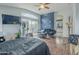 Bedroom with hardwood floors, blue accent wall, a ceiling fan, and a sliding glass door at 6858 W Potter Dr, Glendale, AZ 85308
