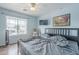 Cozy bedroom with a ceiling fan, TV, rocking chair, and a large window overlooking the neighborhood at 6858 W Potter Dr, Glendale, AZ 85308