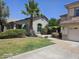 Charming single-story home with well-maintained landscaping and mature palm trees, under a clear blue sky at 6858 W Potter Dr, Glendale, AZ 85308