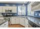 Kitchen area with stainless steel appliances, white cabinetry, and a window at 6858 W Potter Dr, Glendale, AZ 85308