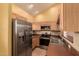 Well-lit kitchen with wooden cabinets, stainless steel appliances, and tiled backsplash and flooring at 7101 W Beardsley Rd # 1403, Glendale, AZ 85308