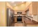 Well-lit kitchen with wooden cabinets, stainless steel appliances, and tiled backsplash and flooring at 7101 W Beardsley Rd # 1403, Glendale, AZ 85308