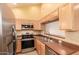 Well-lit kitchen with wooden cabinets, stainless steel appliances, and tiled backsplash and flooring at 7101 W Beardsley Rd # 1403, Glendale, AZ 85308
