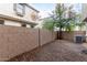 View of the backyard featuring neutral colored walls, gravel landscaping, and a shade tree at 7516 S 31St Pl, Phoenix, AZ 85042