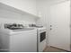 Laundry room with white washer and dryer, a storage shelf, and door to the backyard at 7516 S 31St Pl, Phoenix, AZ 85042