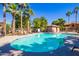Community swimming pool surrounded by palm trees and lounge chairs on a sunny day at 7516 S 31St Pl, Phoenix, AZ 85042