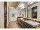 Bathroom featuring dual sinks, granite countertops, dark cabinets, and a glass-enclosed shower at 7601 E Indian Bend Rd # 1050, Scottsdale, AZ 85250