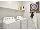 Functional laundry room equipped with modern washer and dryer, plus storage shelves at 10035 S Palo Verde Dr, Apache Junction, AZ 85120