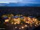 Expansive property at dusk with a Southwest design, desert landscaping and views of the city lights at 10092 E Troon North Dr, Scottsdale, AZ 85262