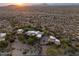 Panoramic aerial view of a desert estate with multiple buildings, a putting green, and a scenic desert backdrop at 10092 E Troon North Dr, Scottsdale, AZ 85262