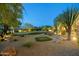 Expansive backyard featuring a putting green, desert landscaping, and mature trees at 10092 E Troon North Dr, Scottsdale, AZ 85262
