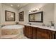 Bright bathroom featuring a soaking tub, wood cabinets, and marble countertops at 10092 E Troon North Dr, Scottsdale, AZ 85262