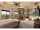 Spacious bedroom features a stone fireplace, sitting area, and views of the outdoors at 10092 E Troon North Dr, Scottsdale, AZ 85262