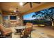 Relaxing covered patio with outdoor fireplace, comfortable seating, and desert landscaping views at 10092 E Troon North Dr, Scottsdale, AZ 85262