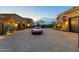 Long, brick driveway leads to a luxury home with a red sports car in view at 10092 E Troon North Dr, Scottsdale, AZ 85262