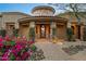 An arched entrance with stone accents and lush flowers welcomes you to the Southwest home at 10092 E Troon North Dr, Scottsdale, AZ 85262