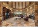 Spacious living room with beamed ceilings, stone fireplace and large windows with desert views at 10092 E Troon North Dr, Scottsdale, AZ 85262