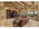Spacious living room with beamed ceilings, stone fireplace and large windows with desert views at 10092 E Troon North Dr, Scottsdale, AZ 85262