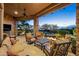 Comfortable outdoor living space with covered patio, outdoor fireplace, and desert landscaping at 10092 E Troon North Dr, Scottsdale, AZ 85262